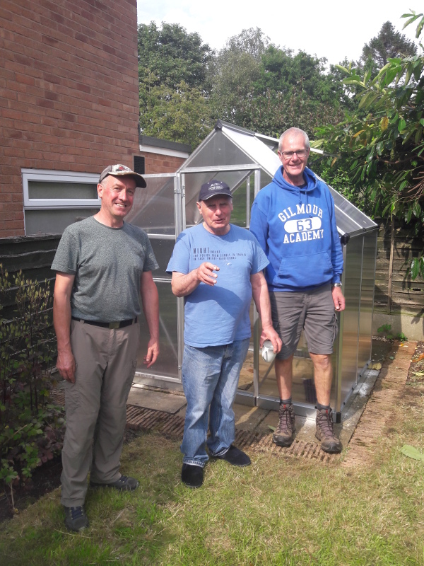 Picturo of the fully built greenhouse with Marcus, Paul and Barry.