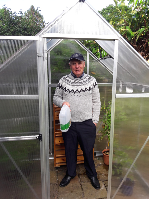 Picture of Paul in his new greenhouse, you can see the tomatoes at the back.