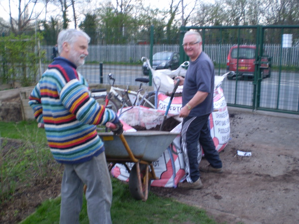 Picture of Colin and the other Barry filling the barrow with top soil